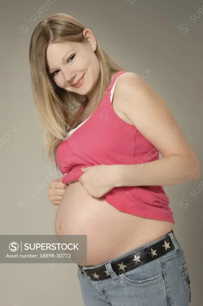 Side view of a pregnant woman looking at the camera