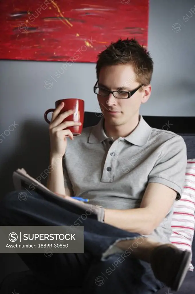 Man writing while sitting with hot drink