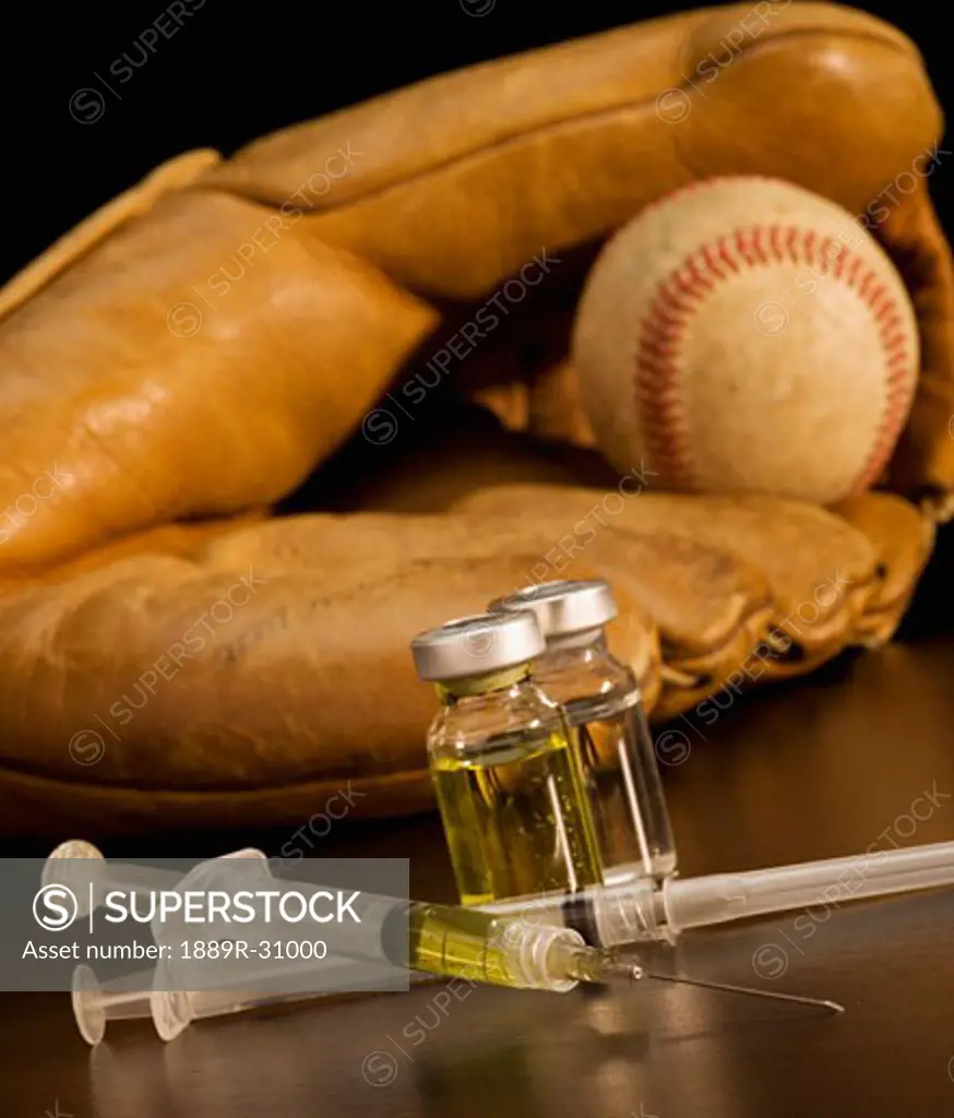 Syringes with vials and baseball glove in the background