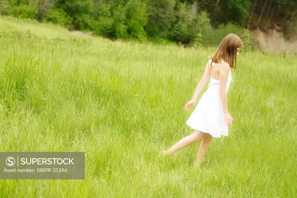 Girl walking through long grass