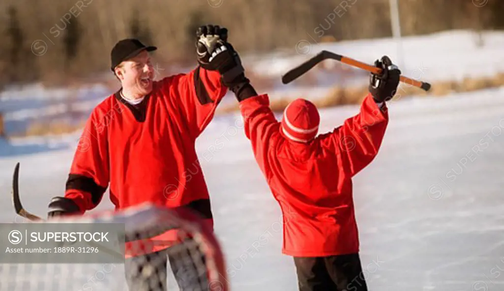 Father playing hockey with son