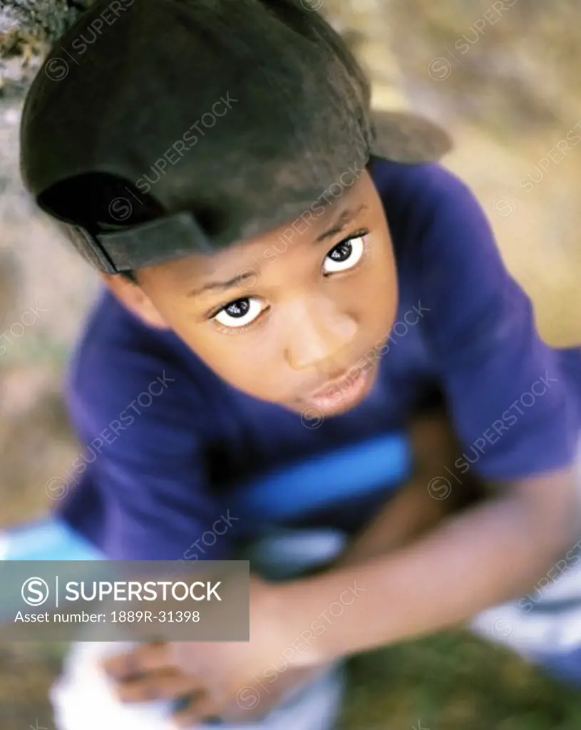 Boy with baseball cap looking up