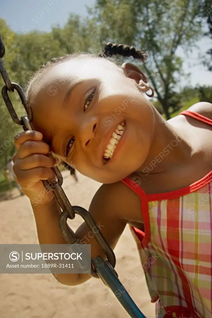 Young girl posing while sitting on a swing