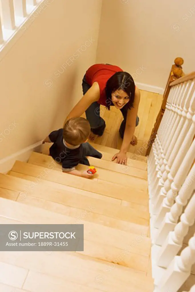 Mother and son crawling up stairs