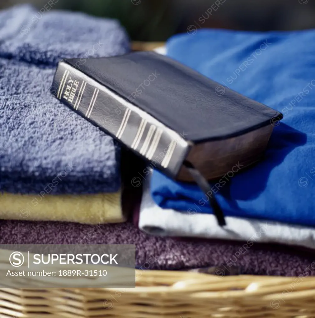 Bible placed on top of folded laundry