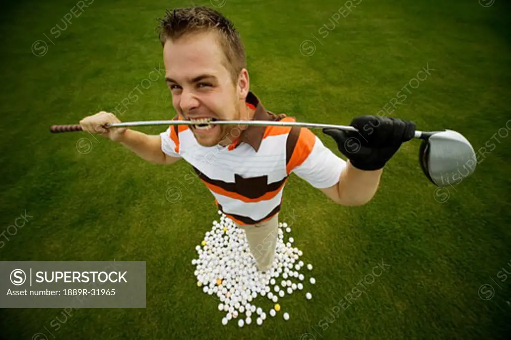 Frustrated golfer standing with balls