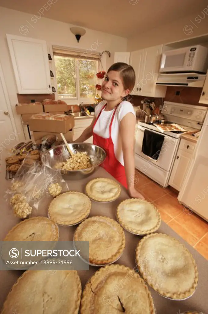 Girl standing in kitchen with pies
