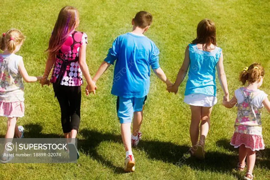 Rear view of a kids walking and holding hands