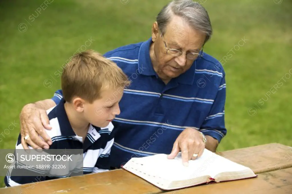 Grandfather and grandson reading the Bible