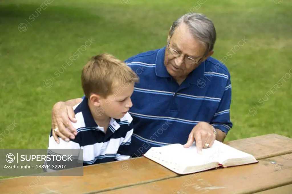 Grandpa and grandson reading the Bible