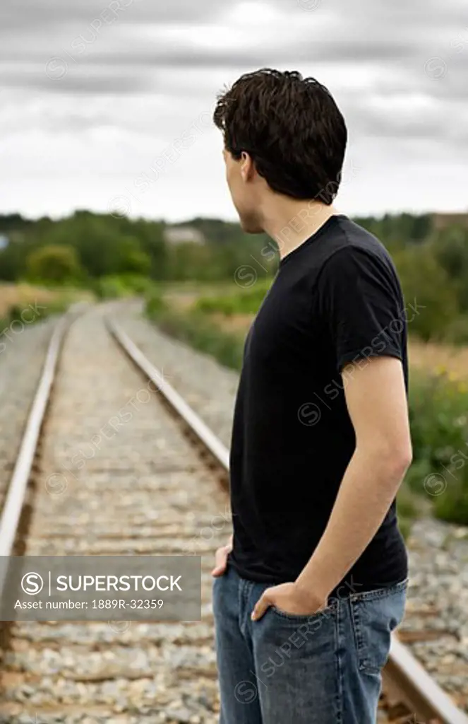 Side view of a man standing on train track