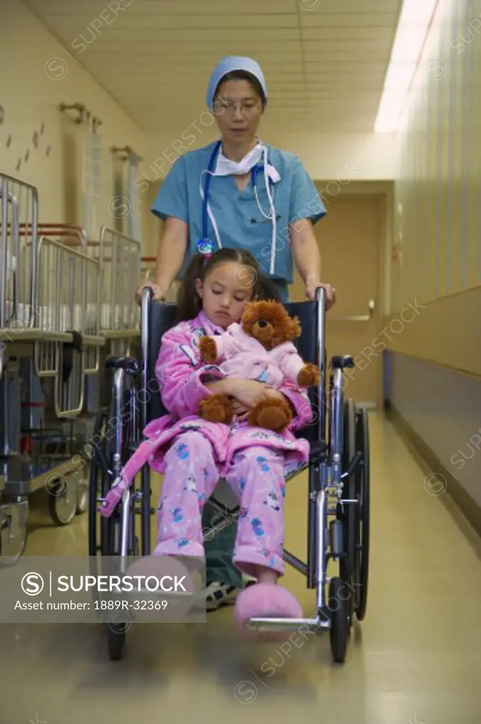 Doctor pushing girl in wheelchair