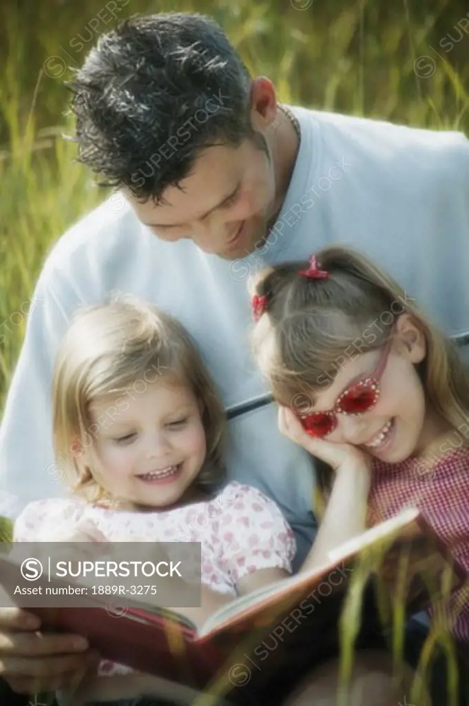 Father reading to his daughters