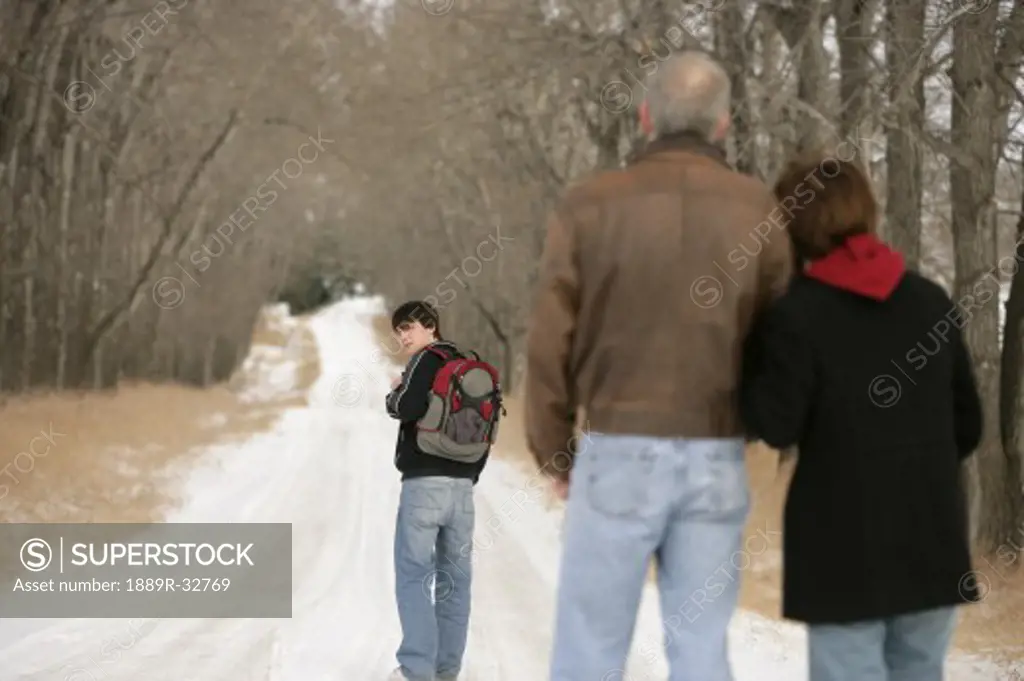 A teenage boy walking on a snow-covered path