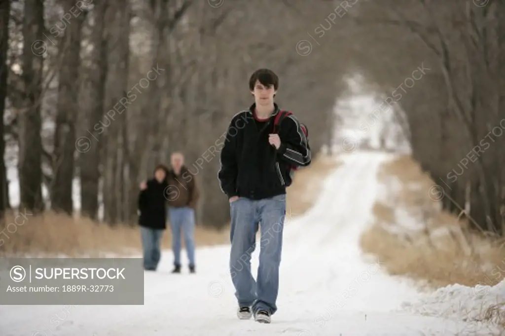 A teenage boy walking away from his parents