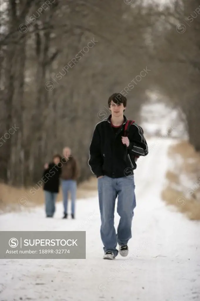 A teenage boy walking away from his parents