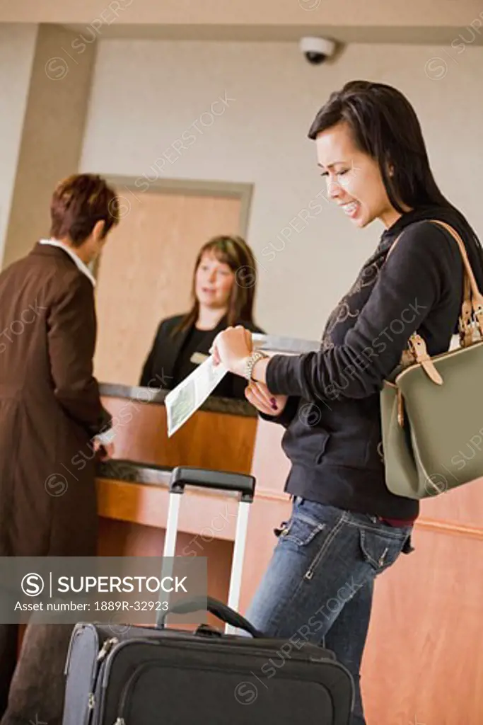 Woman checking time in hotel lobby