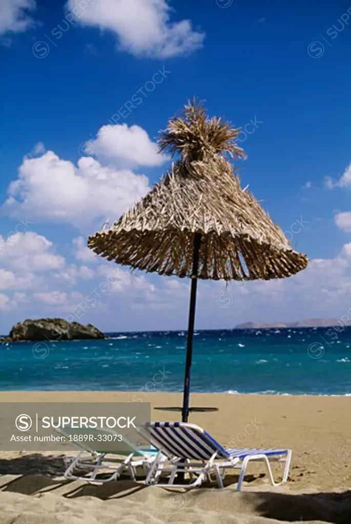 Beach chairs and umbrella on beach, Crete, Greece