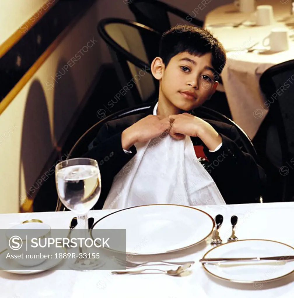 A boy ready to eat a formal dinner
