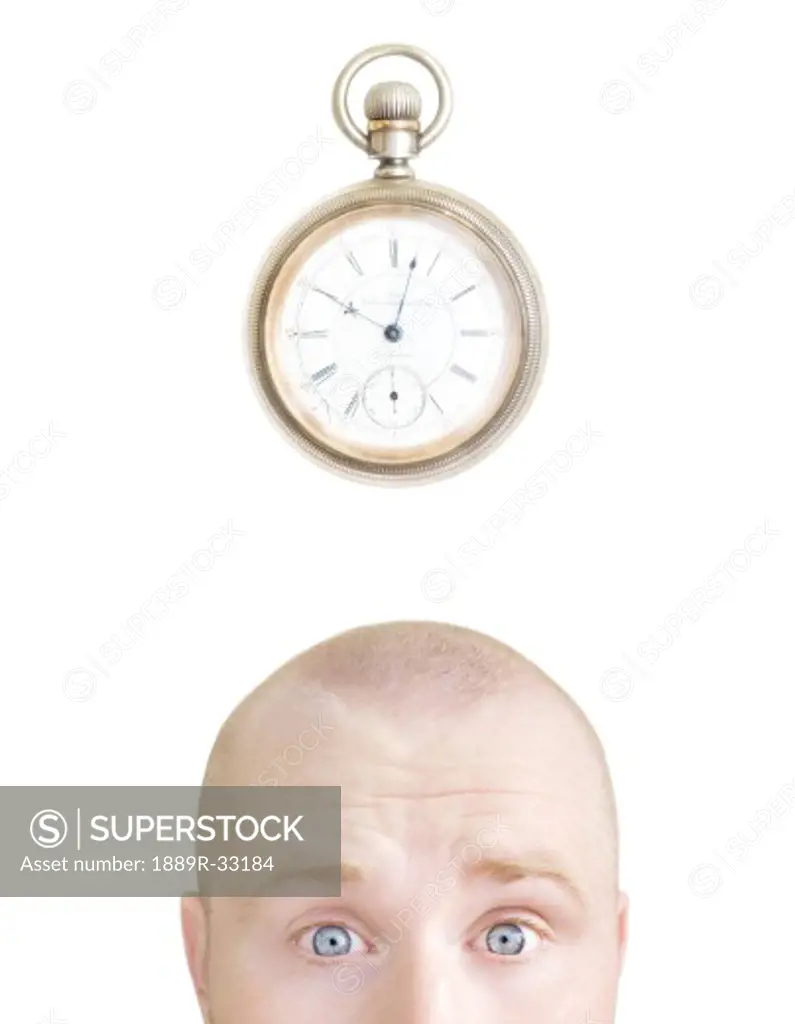 Part of a man's head and a stop watch