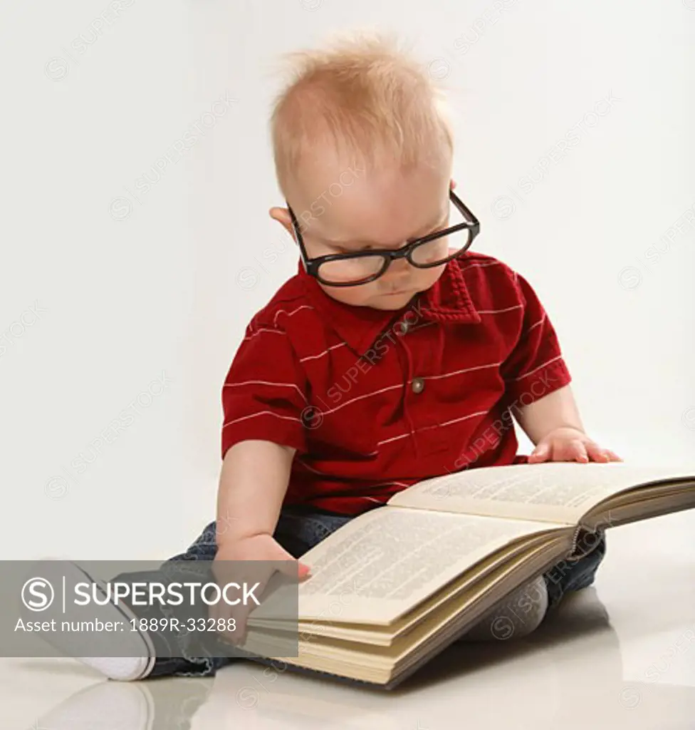 A baby boy looking at a book