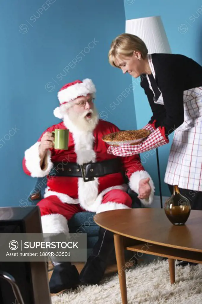 A woman serving pie to Santa