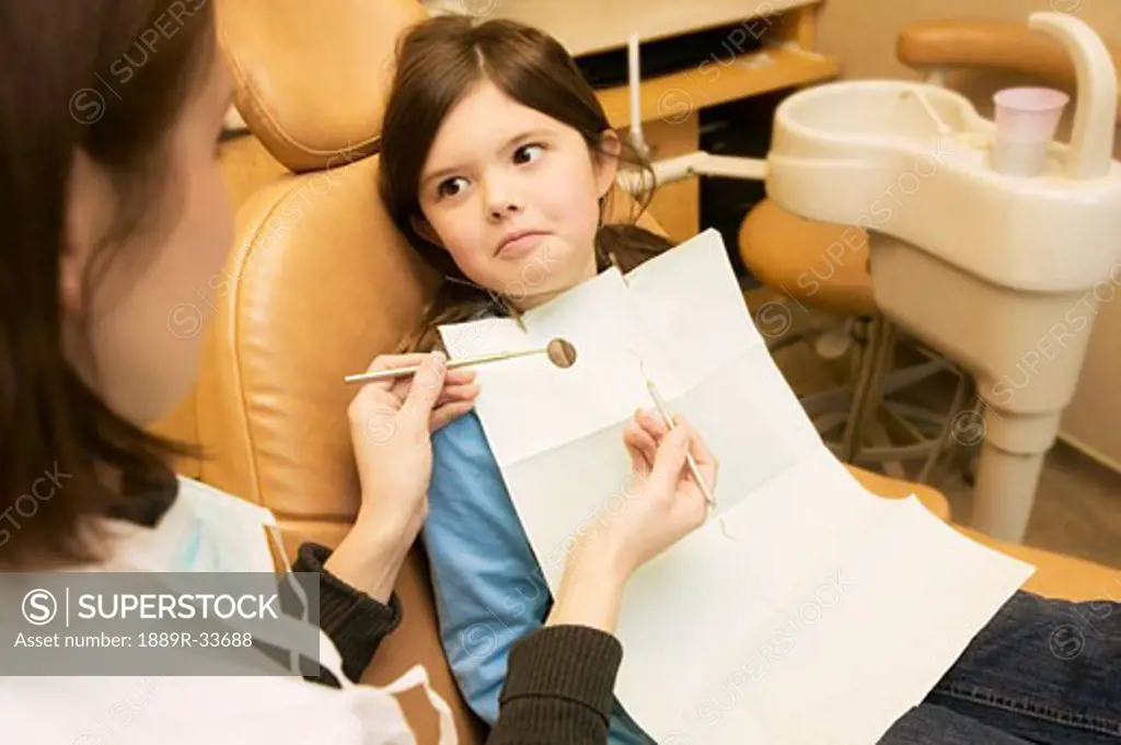 Girl looking at dentist with fear