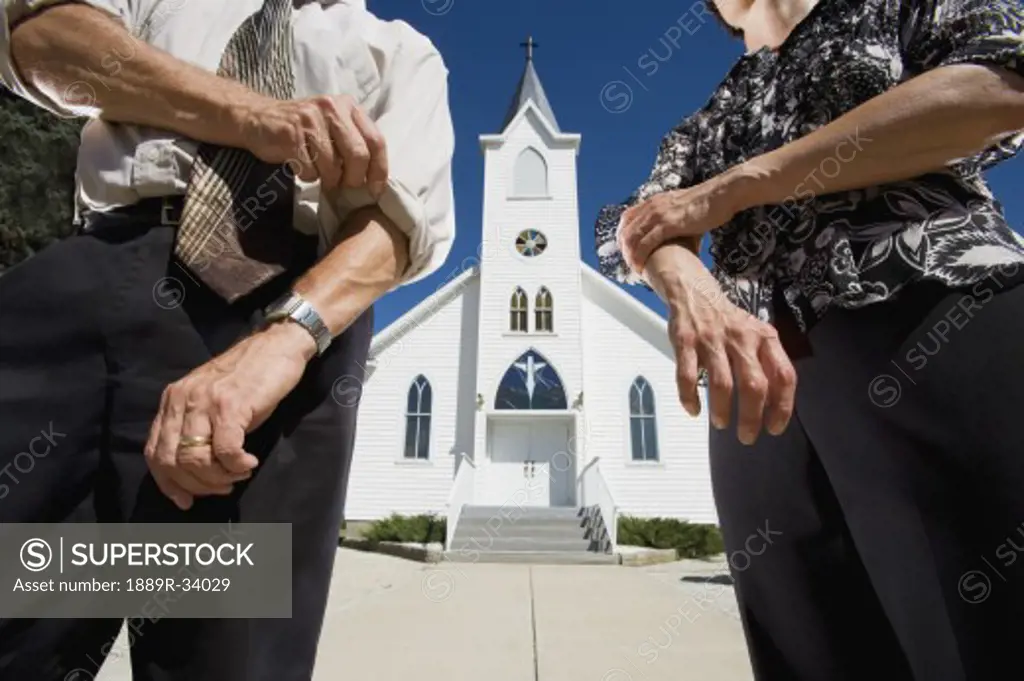 Couple rolling up sleeves in front of church