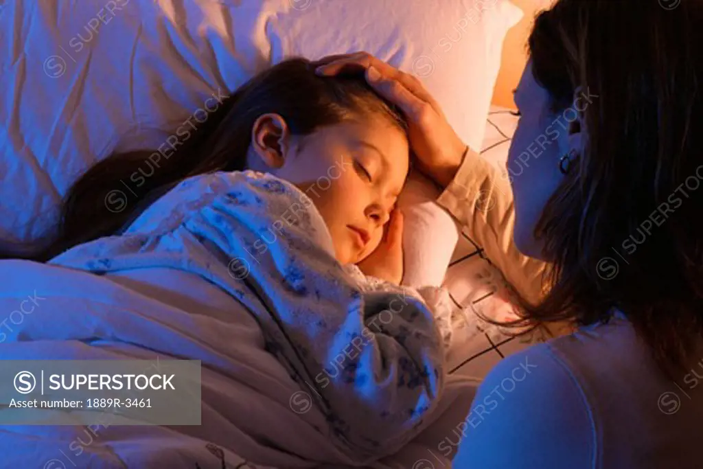 Mother beside sleeping daughter