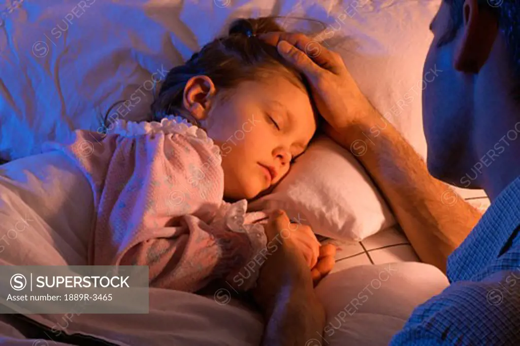 Father beside sleeping daughter bed
