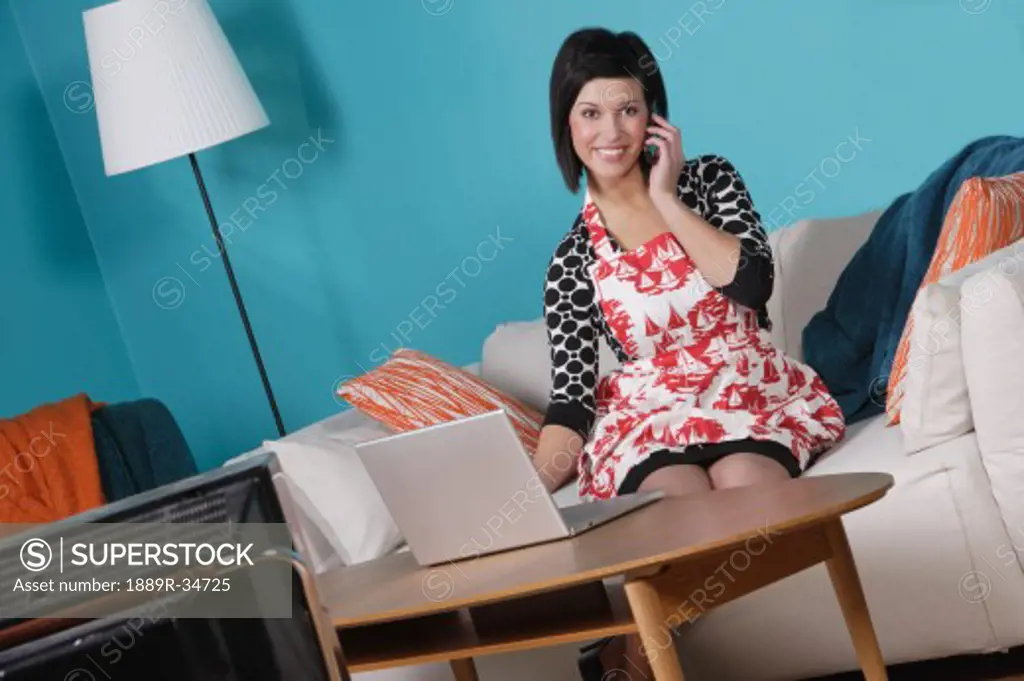 Woman at home talking on the phone and on the computer