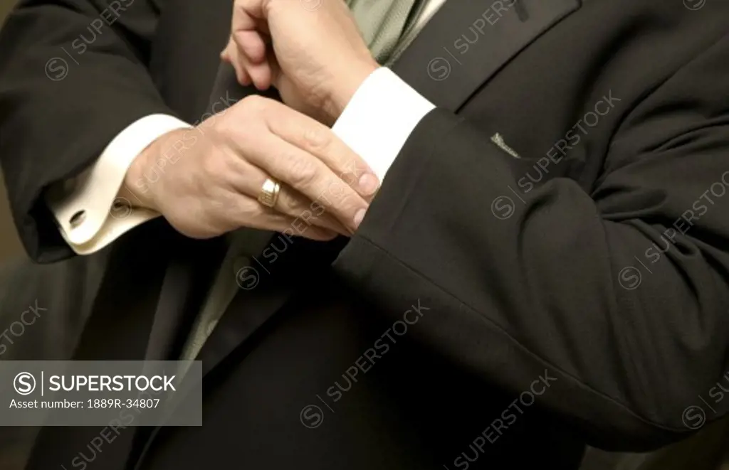 Man adjusting cuffs on suit