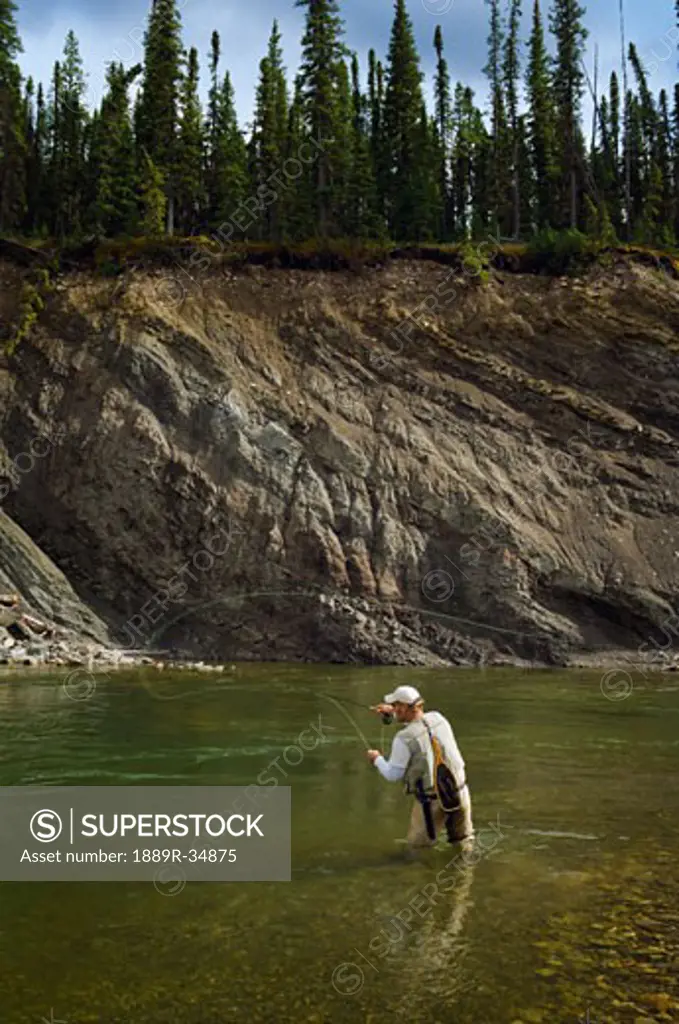 Man fly fishing in a mountain river, Nordegg, Alberta, Canada