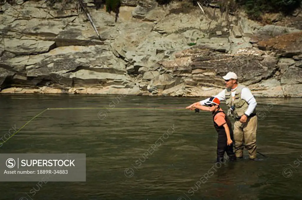 Father and son fly fishing in a river, Nordegg, Alberta, Canada  