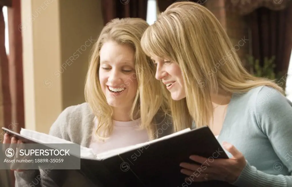Women laughing and looking at photo album