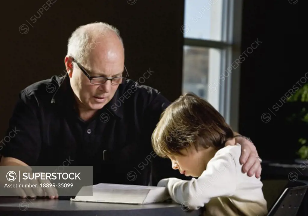 Grandpa helping a child to read