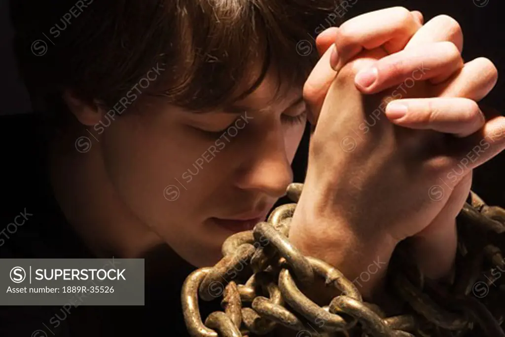 Man in chains praying