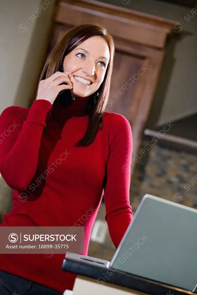 Woman with laptop talking on the phone