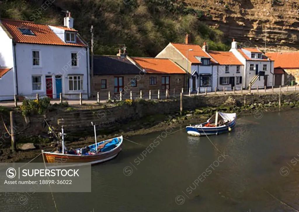 Boats moored on river, Staithes, Yorkshire, England