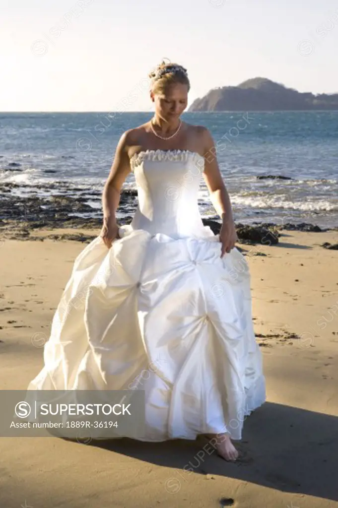 Woman in wedding dress on beach