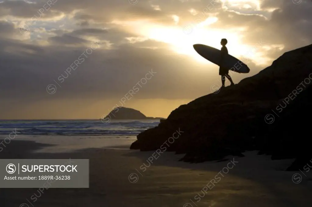 A surfer on Muriwai Beach, New Zealand
