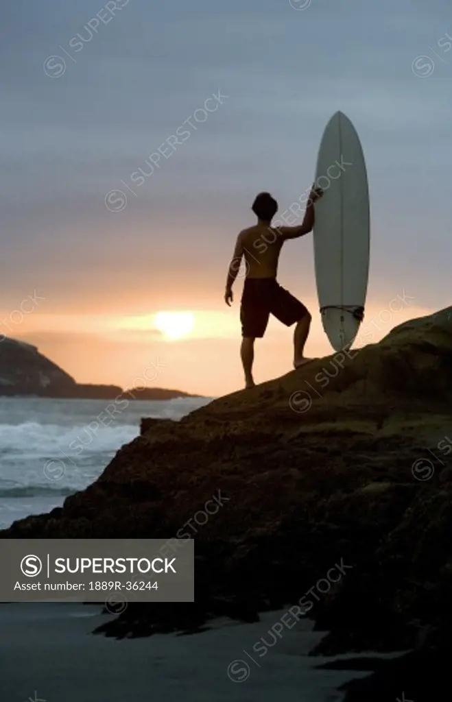 A surfer on Muriwai Beach, New Zealand