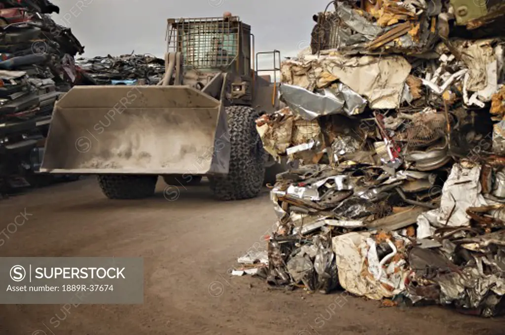 A tractor driving through stacks of compacted rubbish