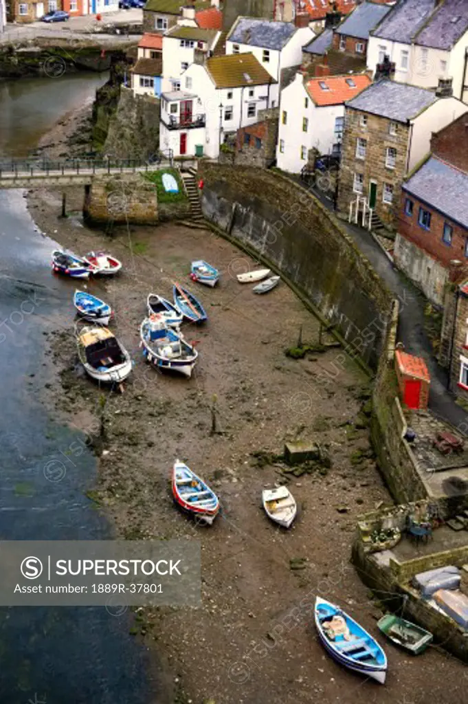Boats beached on the riverbank, Staithes, North Yorkshire, England