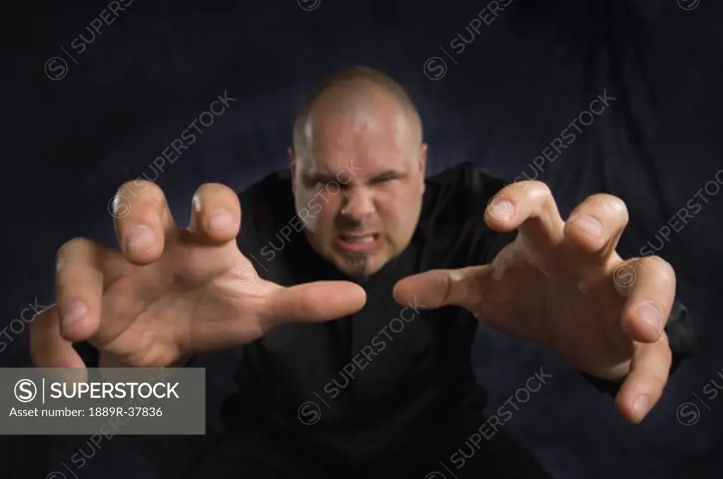 An angry man reaching towards the camera aggressively