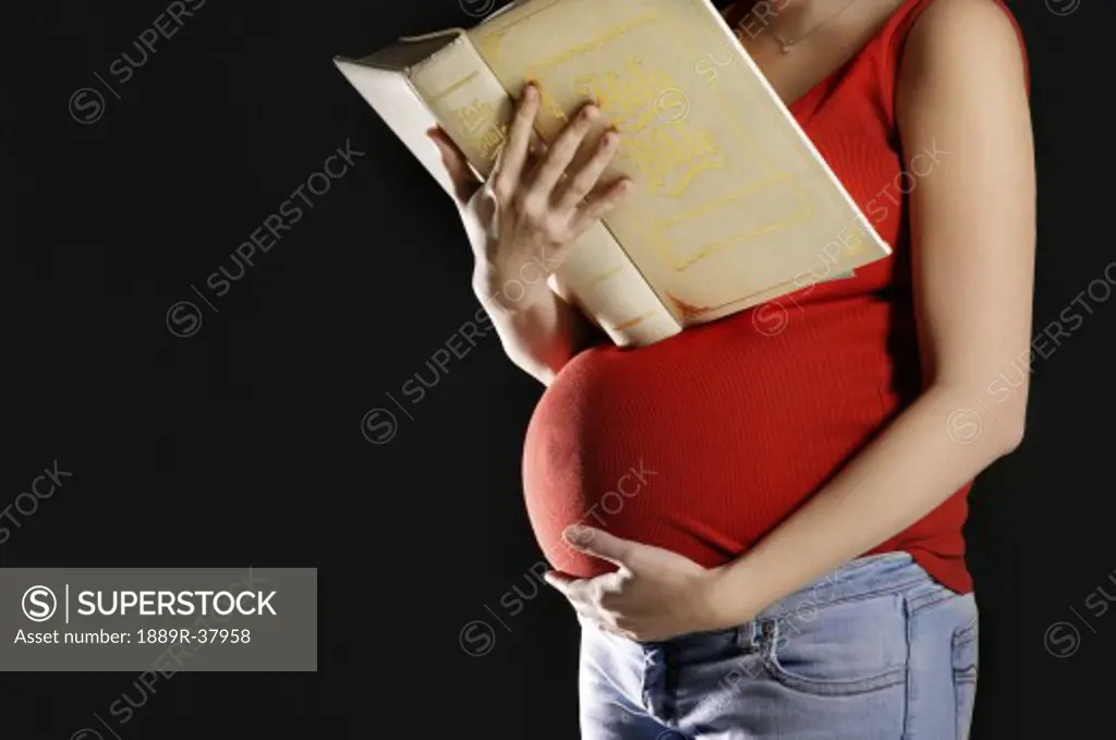 Pregnant woman reading a Bible