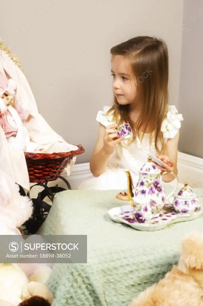 Girl having a tea party with teddy bears