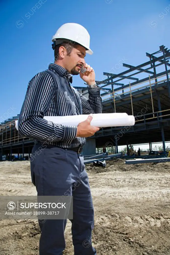 Architect on the phone at building site