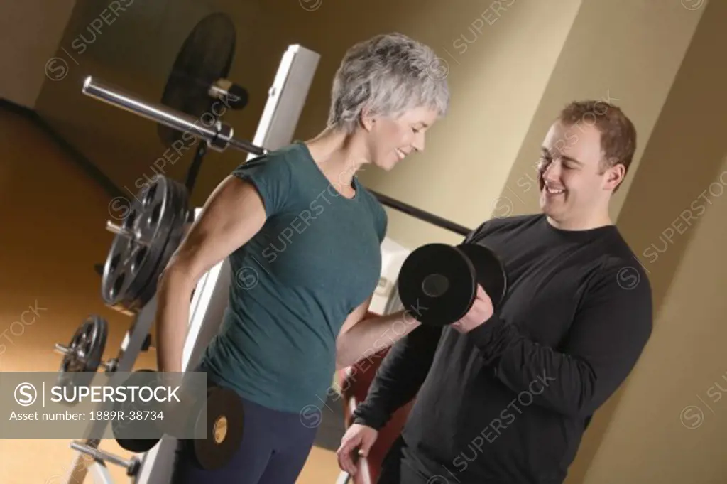 Woman being shown how to lift weights