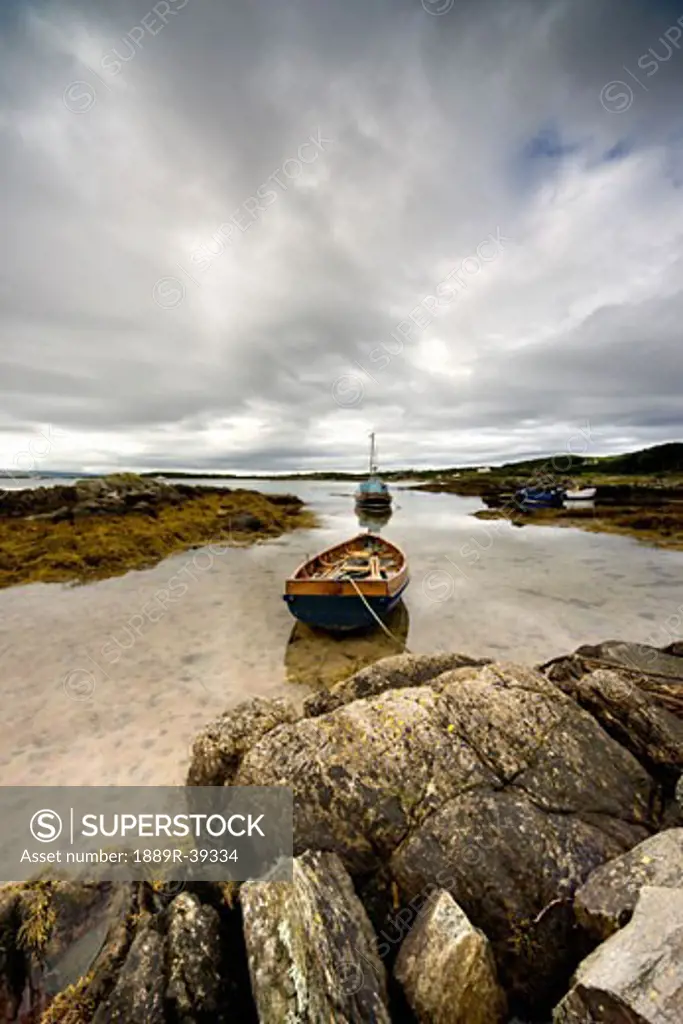Boat tied to rocks on shore